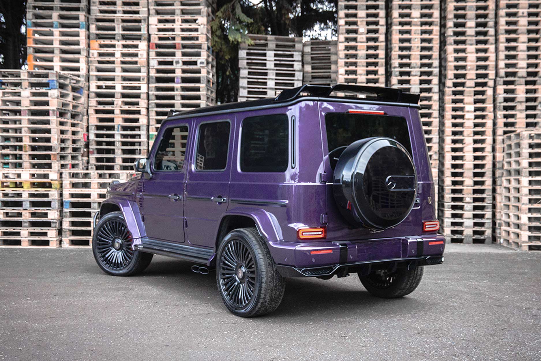 Rear quarter view of a Purple Mercedes G Wagon 2018+. Shot outside a park backdrop. Fitted with Barugzai Casanova 22/23” alloy wheels, in Gloss Black.