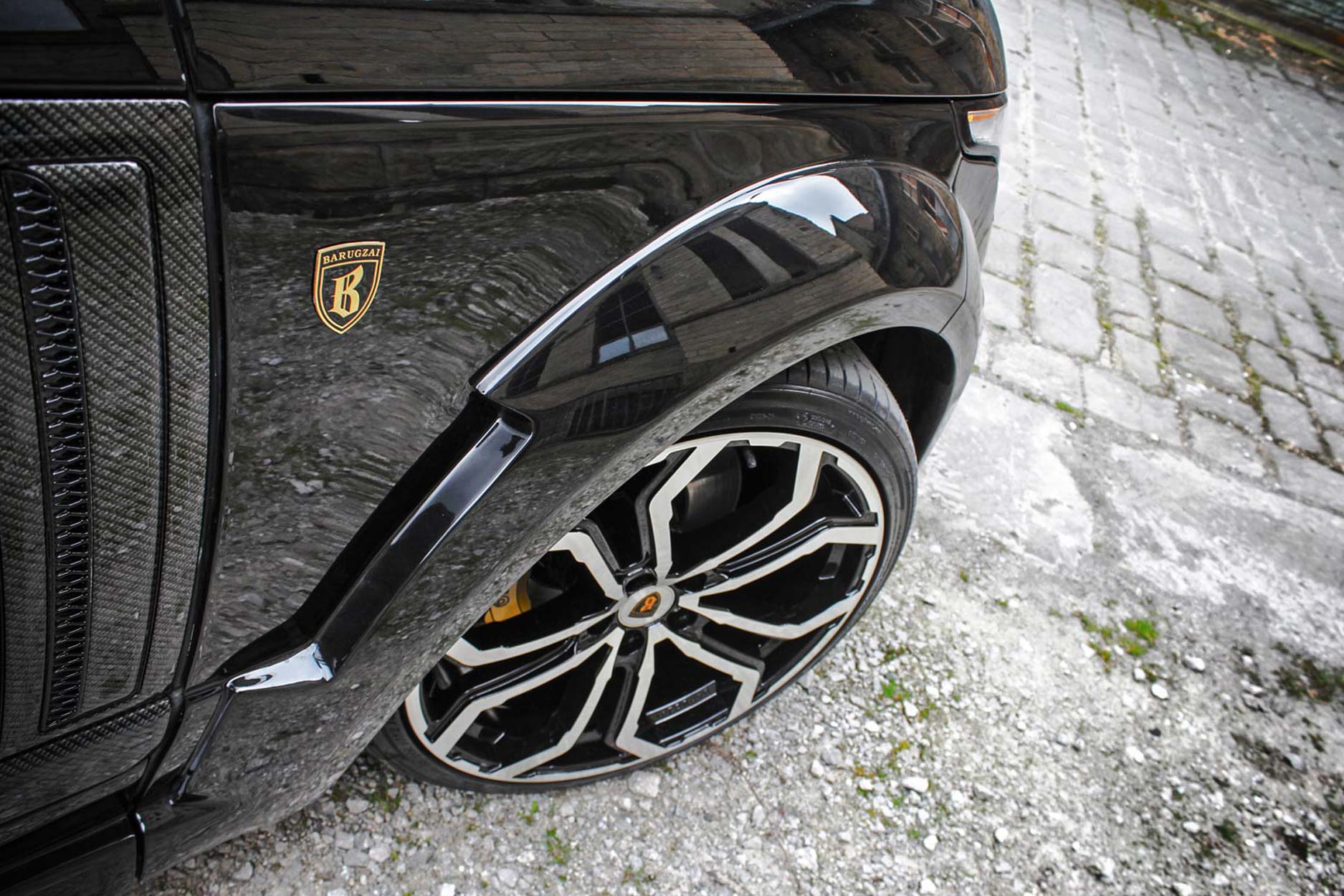 Front quarter view of a Black Range Rover Vogue L405 2013-2017. Shot outside an old mill. Fitted with Barugzai Opium 22” alloy wheels, in Gloss Black Polished Face.
