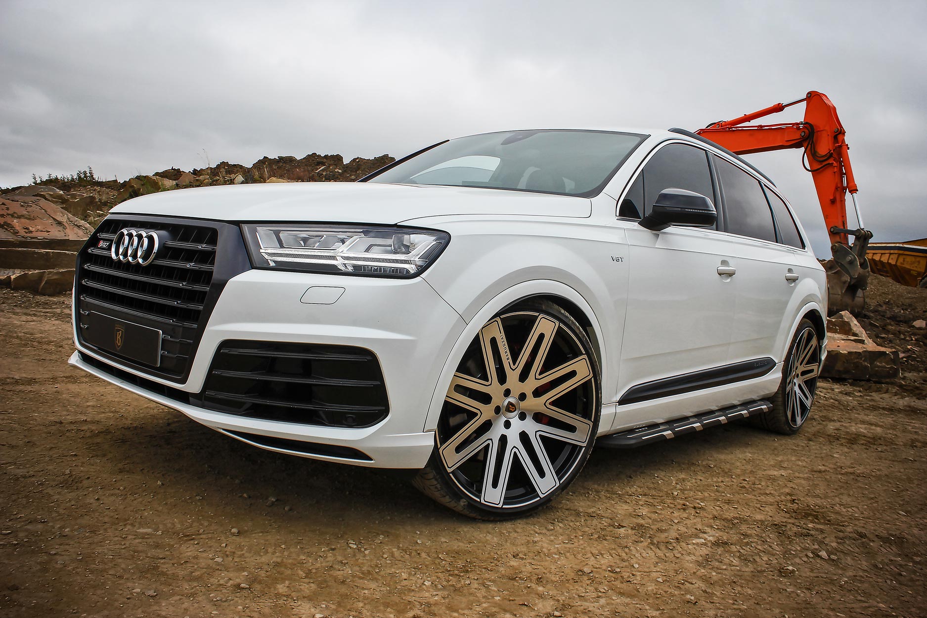 Front quarter view of a White Audi Q7 2016+. Shot outside a quarry. Fitted with Barugzai EXEL 24” alloy wheels, in Gloss Black Polished Face.